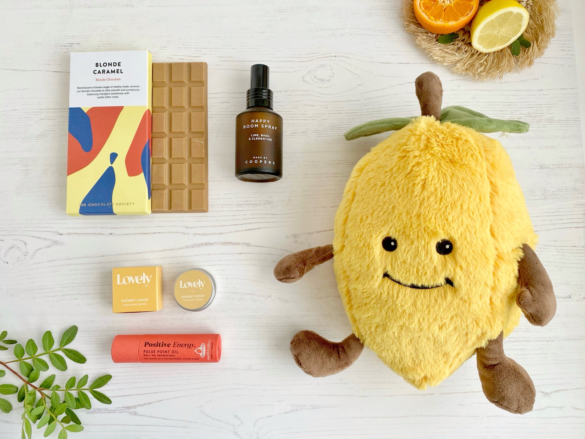 Mood Boost Care Package with lemon soft cuddly toy, happy room mist spray, blonde chocolate bar, sherbert lemon lip balm, positive energy roll on oil