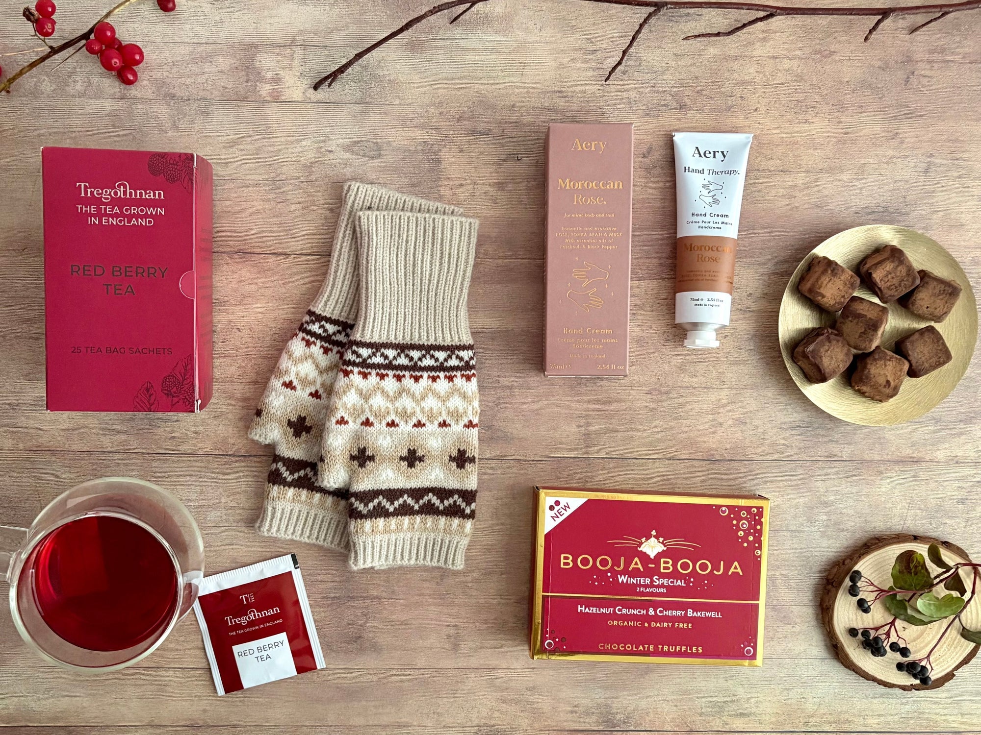 Winter Self Care gift hamper nordic patterned gloves, truffles, red berry tea, rose handcream on flatlay