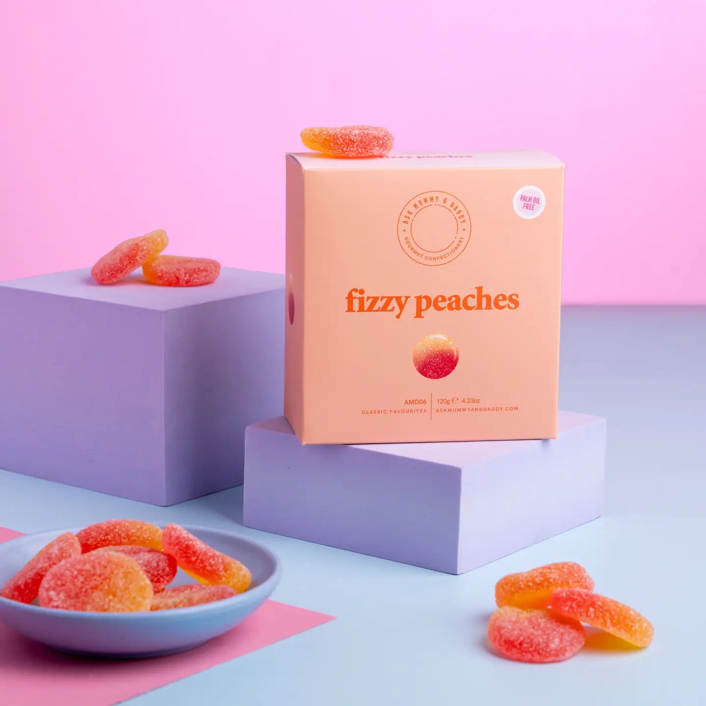 Box of 'fizzy peaches' gummy candies with gummies on a white background