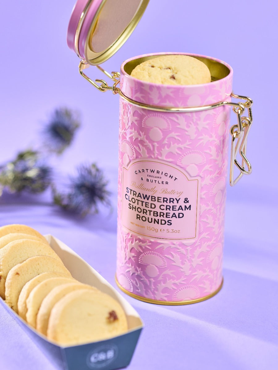 Pink cylindrical  tin with 'Cartwright & Butler' branding on a purple background. Strawberry & clotted cream shortbread biscuits
