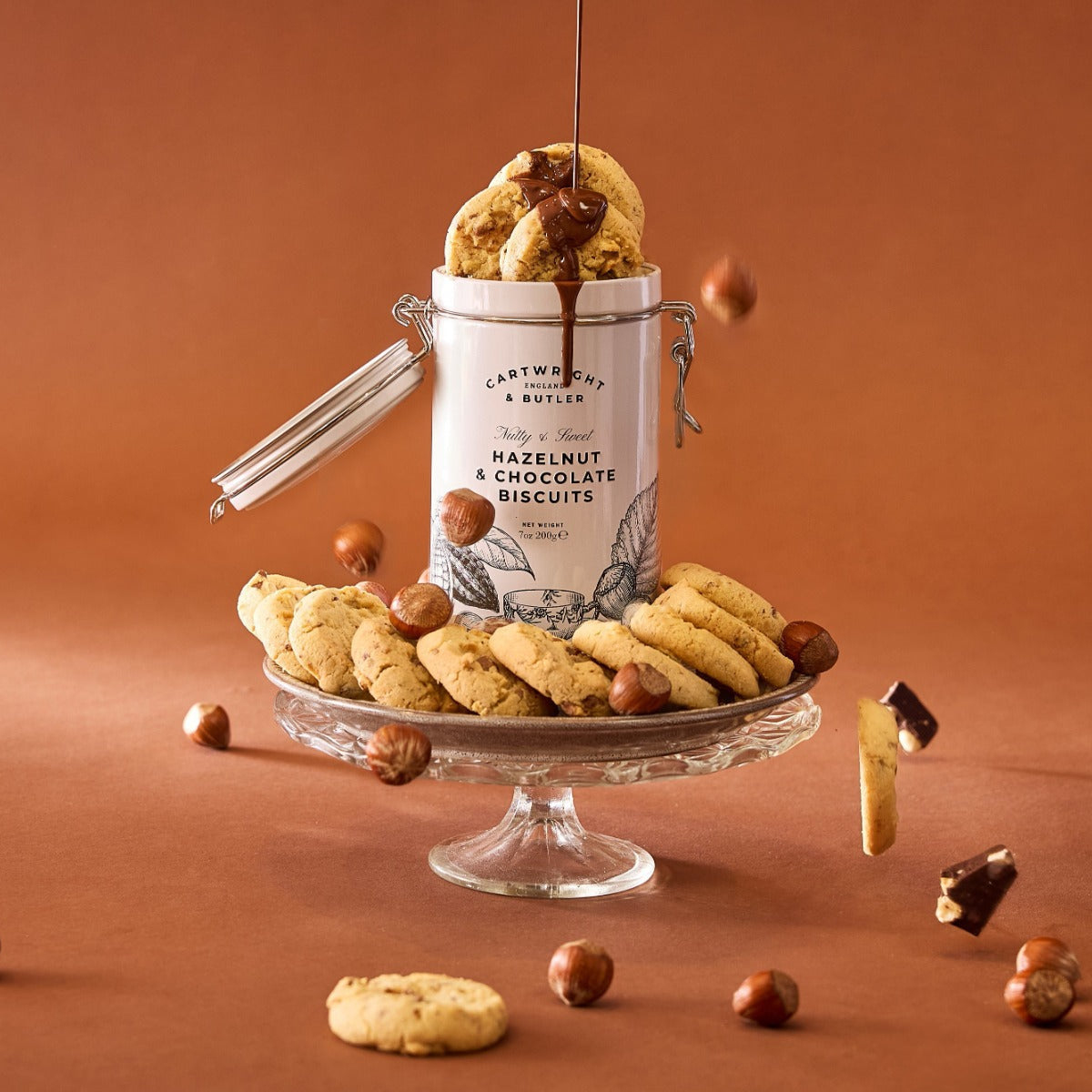 Hazelnut and chocolate cookies with a tin on a brown background