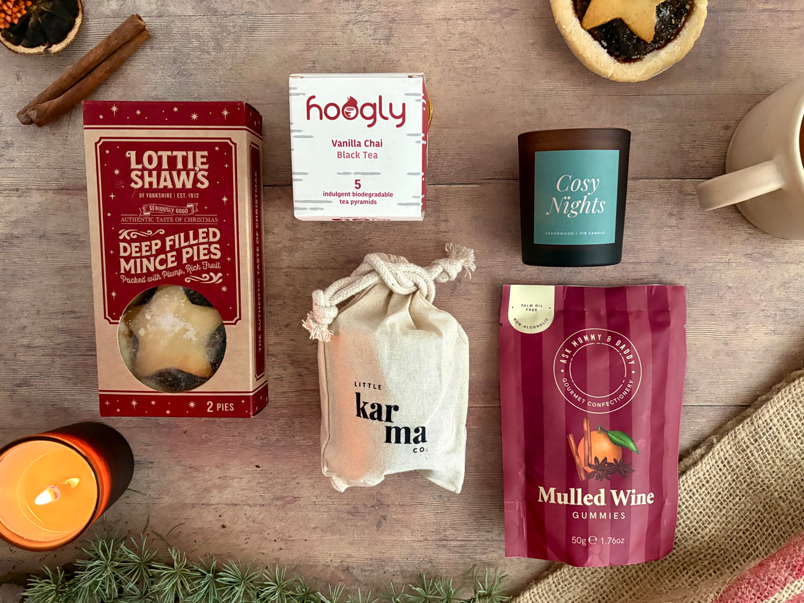 Fireside Snug Christmas gift hamper with mince pies, vanilla chai tea, Cosy Nights candle, mulled wine gummies and a Little Karma candle gift bag.
