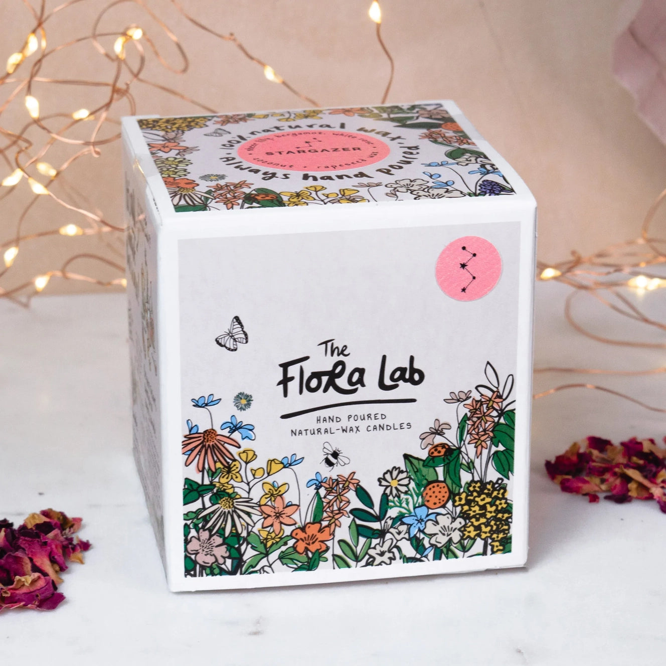 Stargazer flora lab candle on white background . Amber glass jar candle with dusky pink label