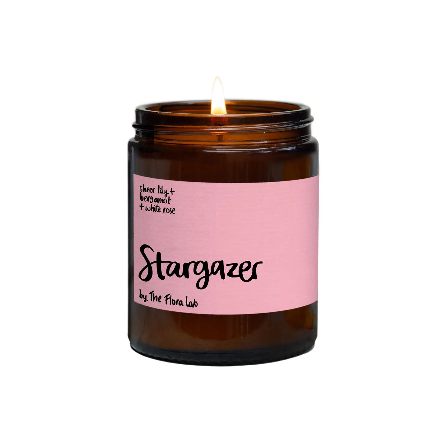 Stargazer flora lab candle on white background . Amber glass jar candle with dusky pink label