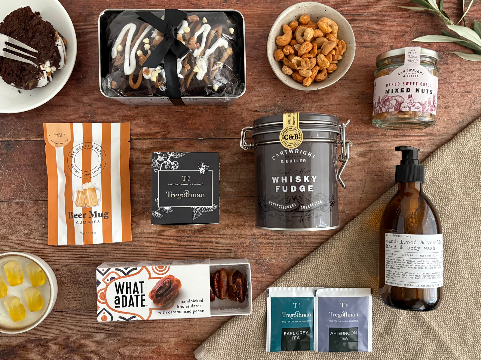 Off Duty Care Package with chocolate cake, tea, dates, nuts, beer gummy sweets, whisky fuge, and sandalwood body wash