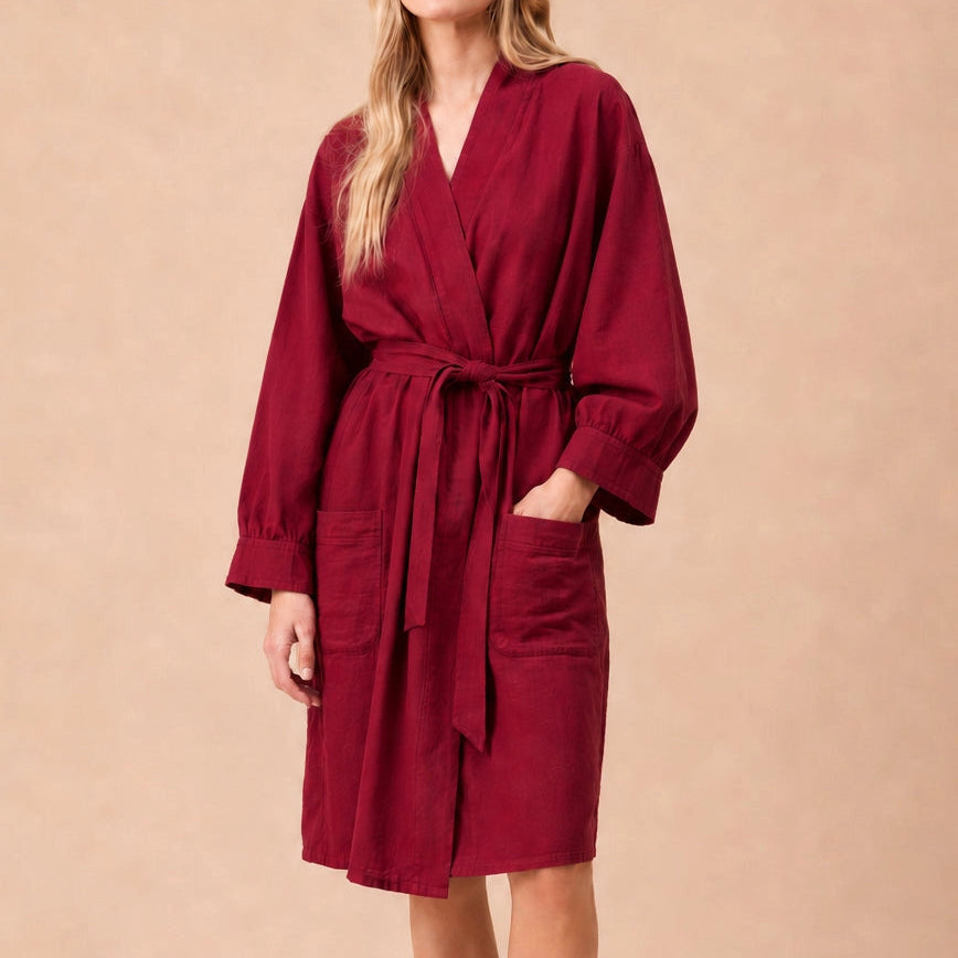 A woman wearing a textured, deep red wrap robe 