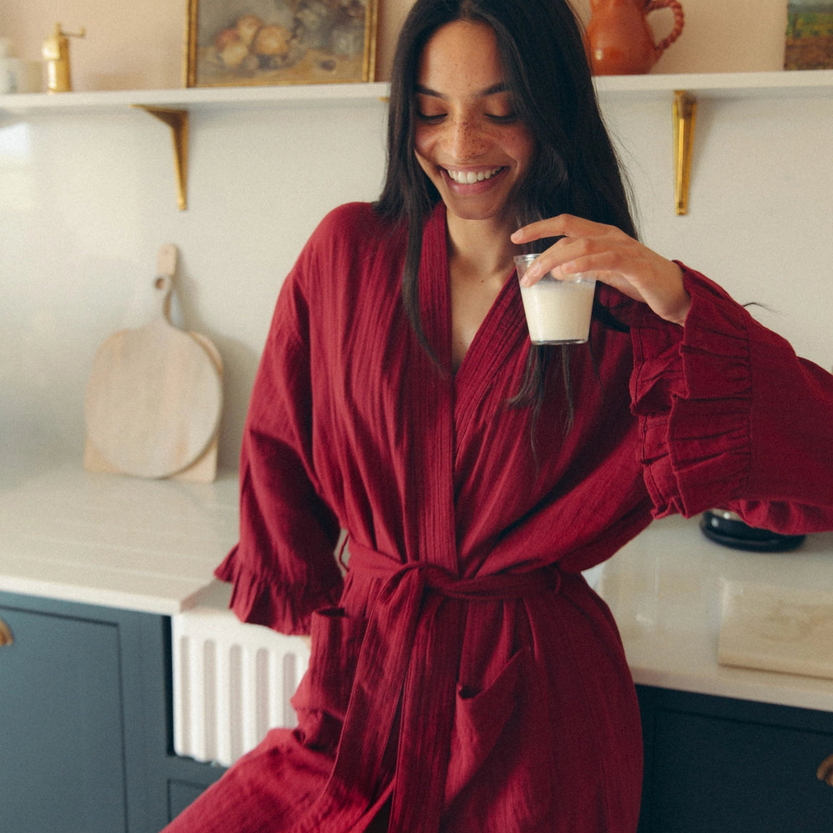A woman wearing a textured, deep red wrap robe 