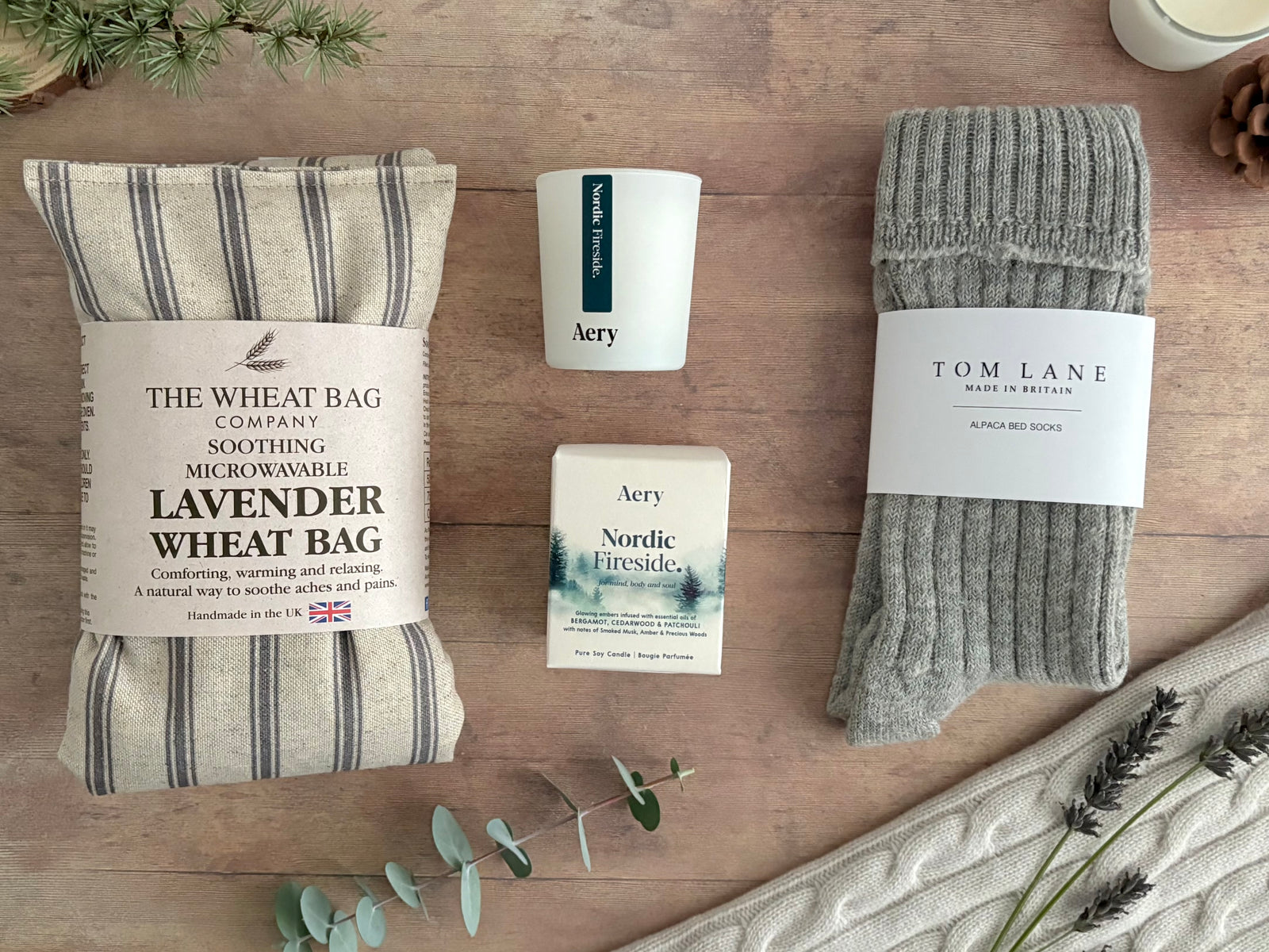 Warm and cosy care package with lavender heatable wheatbag, alpaca bed socks and nordic fireside bergamot and cedar candle